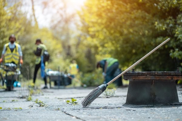 Broom,Lying,On,Street,,Volunteers,Cleaning,Up,Park,From,Dust,